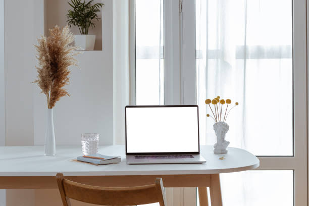 istock Laptop with blank white screen in office desk interior. Stylish workplace mockup. 1314595910