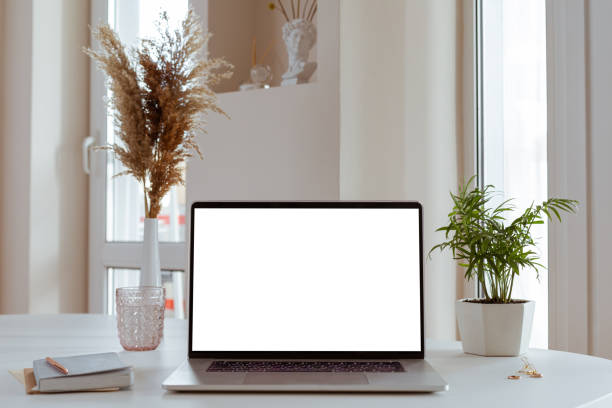 istock Laptop with blank white screen in office desk interior. Stylish workplace mockup. 1314595922