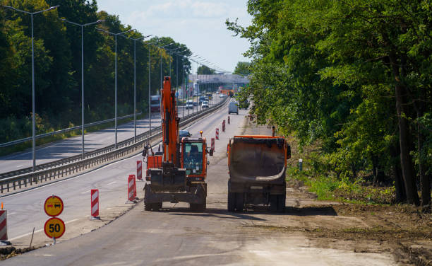 istock Two special trucks drive along road under construction. Road to be paved with asphalt. Selective focus. 1314598670