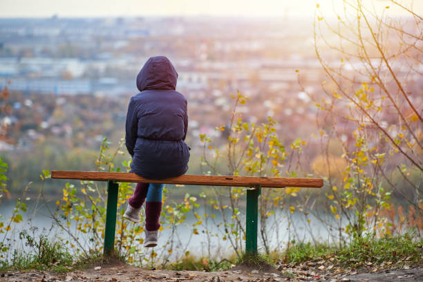 giovane donna seduta in panchina nel parco cittadino autunnale e guardando il paesaggio urbano, vista sul retro - bench mountain park sitting foto e immagini stock