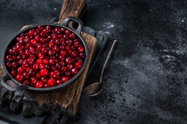 istock Red fresh Cranberry berry in a pan. Black background. Top view. Copy space 1314609233
