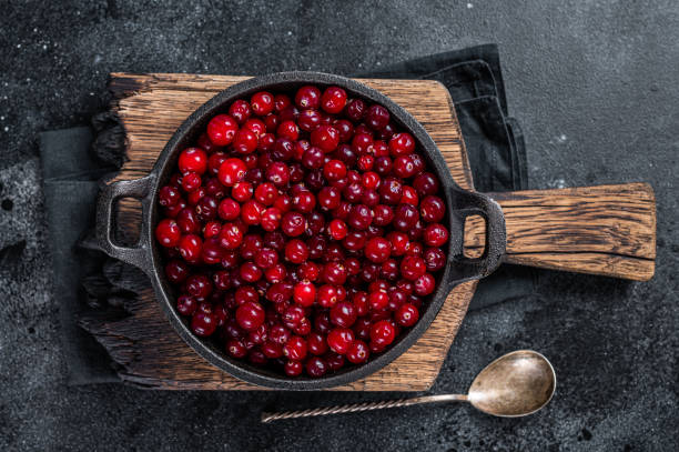 istock Red fresh Cranberry berry in a pan. Black background. Top view 1314609255