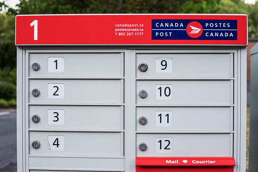 Ottawa, Canada - June 21, 2020: Canada Post mail boxes set in the neighborhood community with red sign in English and French