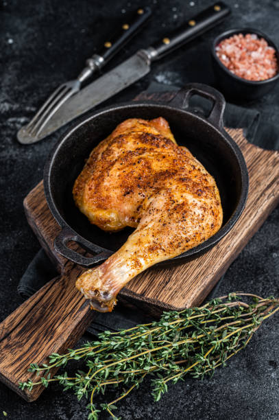 istock Fried bbq chicken leg in a pan. Black background. Top view 1314609854