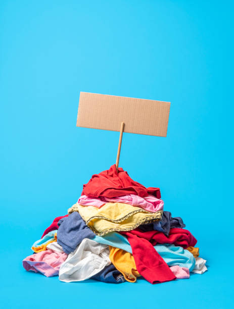 clothes pile on a blue background. textile recycling concept. - pilha roupa velha imagens e fotografias de stock