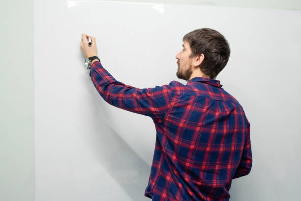 istock A young man works in the office, makes a presentation on a white board, flip chart.Training, lesson, business concept 1314614754
