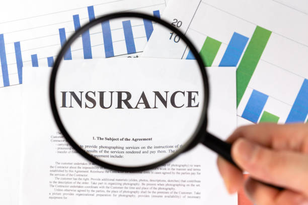 istock Man looking through a magnifying glass to the Blank insurance claim form. 1314614995
