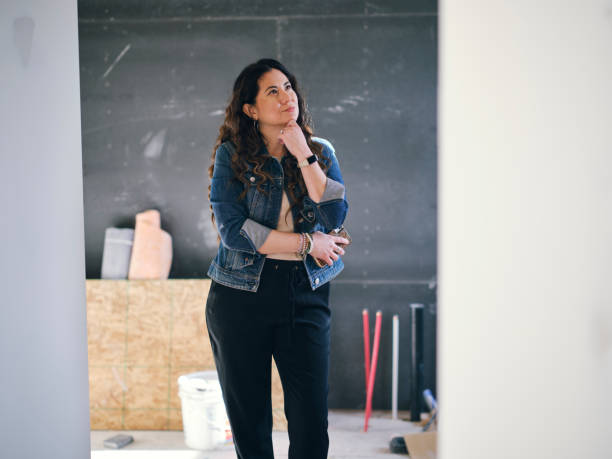 femme regardant une maison en construction - decisions women thinking latin american and hispanic ethnicity photos et images de collection