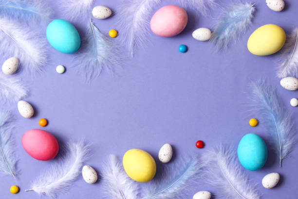 istock Easter composition of painted eggs and feathers on a colored background. 1314619914