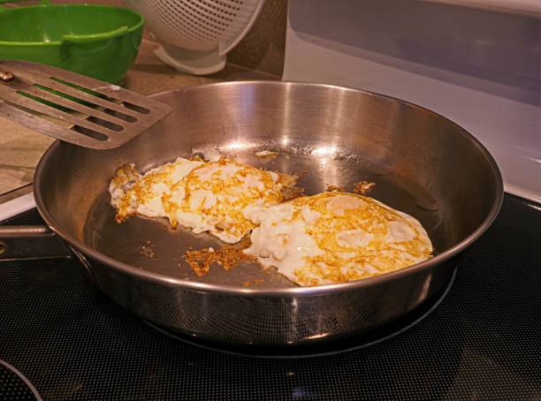 istock Fried eggs cooking in frying pan using olive oil 1314621287