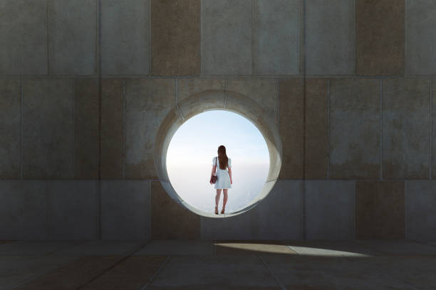 istock Lonely young woman looking through concrete window 1314627515