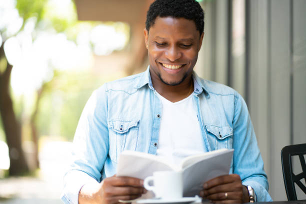 istock Man reading a book at coffee shop. 1314630408