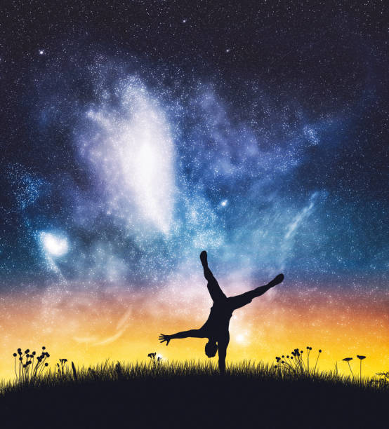 istock Acrobat man standing on one hand on night sky. 1314632725