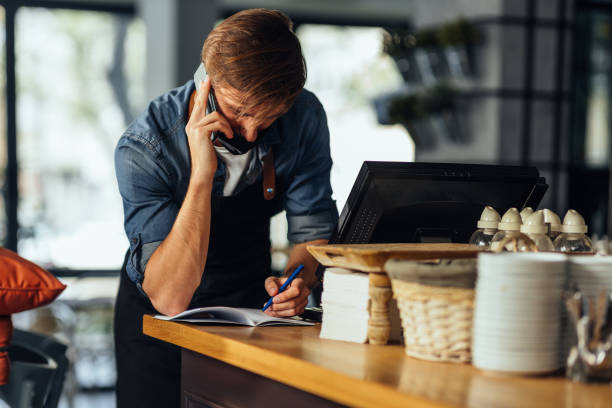 istock Waiter with face mask talking with customer by phone 1314632747