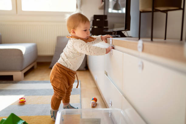 istock Curious baby boy standing on his feet while holding on to the shelf 1314636554