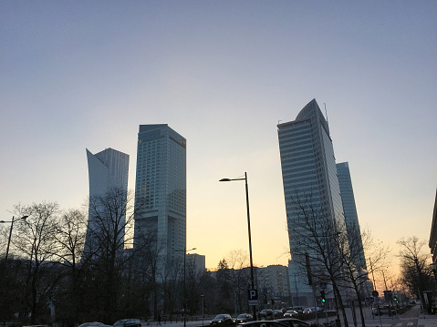 Modern skyscrapers on a big square surrounded with trees are reaching a clear sky at dawn in the city of Warsaw in Poland January 3,2016