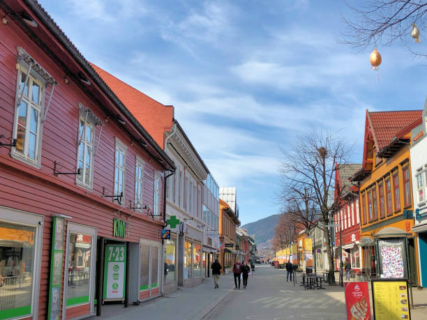 Street scenery with pedestrians between typical nordic buildings and some stores on a sunny day in the city of Lillehammer in Norway April 19,2019