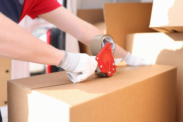 istock Man seals box with adhesive tape dispenser 1314642790