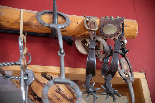 Old western wood logs on red wall with old spurs hanging over it, in Montana, western USA.