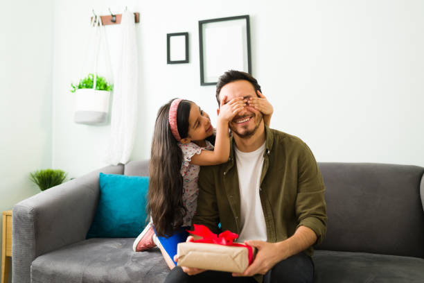 istock Adorable girl surprising her dad with a present 1314659457