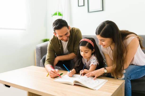 mãe e pai fazendo dever de casa com o filho - mulher jovem desenho adulto livro de colorir em casa - fotografias e filmes do acervo