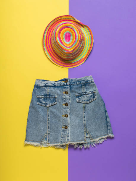 istock Multi-colored hat and denim skirt on a yellow and purple background. 1314665658
