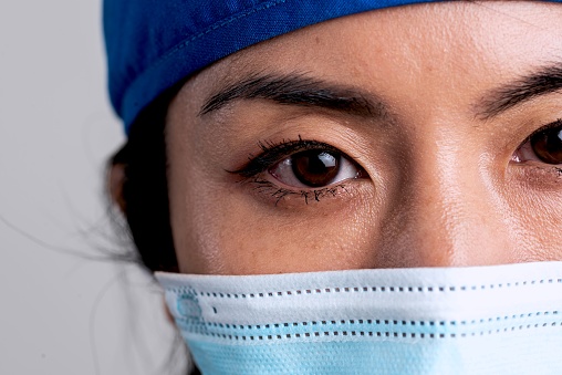 Close up Overworked, pensive, stressed serious asian female healthcare worker looking at the camera