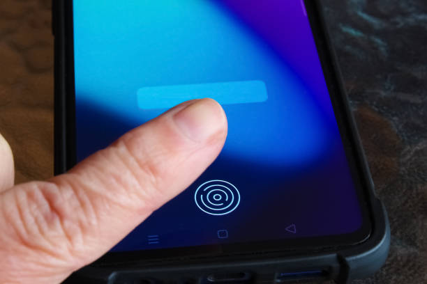 istock Hand holding modern mobile phone showing application with process of scanning fingerprint on a screen. 1314675142
