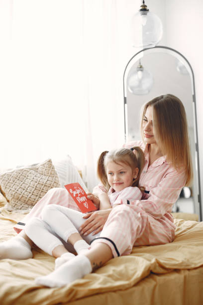 istock Young mother with cute daughter hugging on bed 1314684867