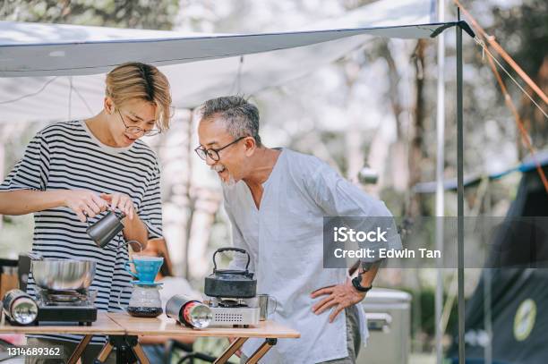 アジアの中国の10代の少年と父親は午後にキャンプテントで家族のためにコーヒーを滴下する準備をしています - 父親のストックフォトや画像を多数ご用意