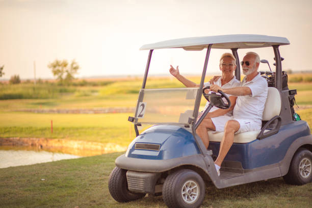 istock An elderly golf couple rides in a golf cart. 1314693933