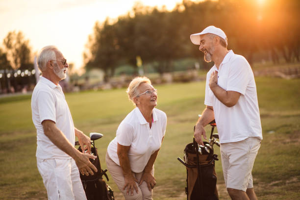 istock Three smiling seniors golfers talking on golf field. 1314694499