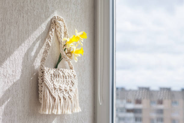 istock Handmade macrame bag  on the light wall. ECO friendly natural macrame cotton bag. Hobby knitting handmade macrame. Modern summer concept. Copy space 1314695243
