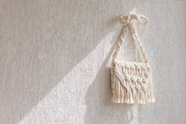 istock Handmade macrame bag  on the light wall. ECO friendly natural macrame cotton bag. Hobby knitting handmade macrame. Modern summer concept. Copy space 1314695253