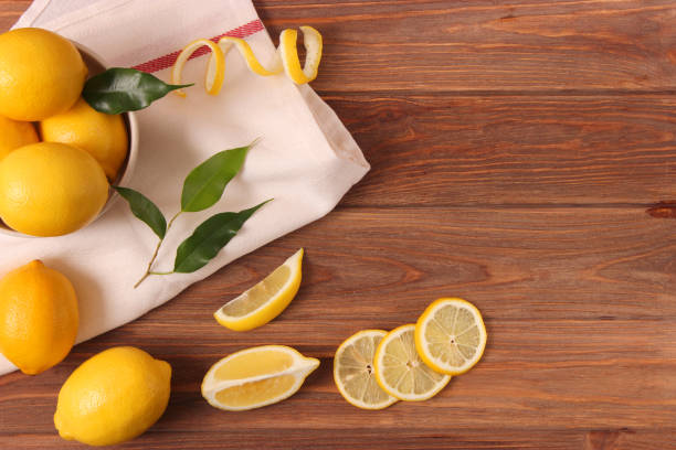 istock lemons and green leaves on a colored background. 1314695371