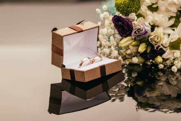 istock wedding rings with  pink flowers on a  grey background 1314696887