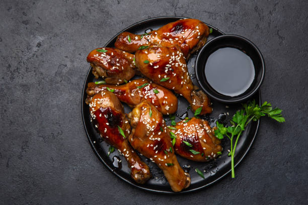 glazed teriyaki chicken legs on black plate