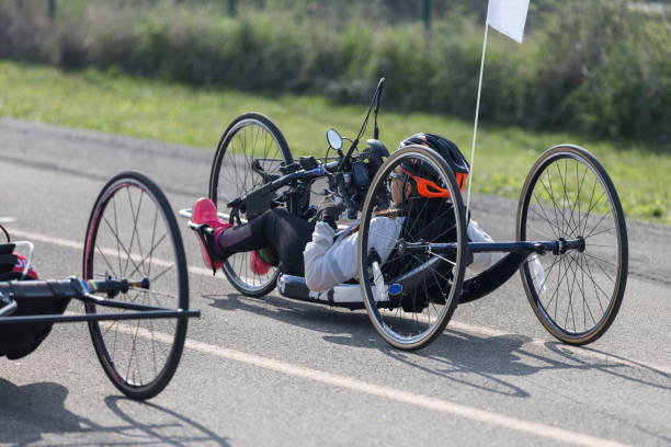atleta chica con casco montando su bicicleta de mano en una pista - physical impairment athlete sports race wheelchair fotografías e imágenes de stock