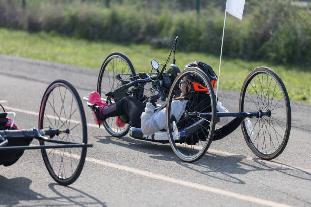 Athlete Girl with Helmet Riding her Hand Bike on a Track Parma, Italy - October 2020: Parma, Italy - October 2020: Athlete Girl with Helmet Riding her Hand Bike on a Track in a Sunny Day in Public Street paralympic games stock pictures, royalty-free photos & images