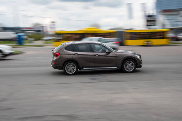 ukraina, kijów - 20 kwietnia 2021: brązowy samochód bmw x1 poruszający się po ulicy. redakcji - bell zdjęcia i obrazy z banku zdjęć