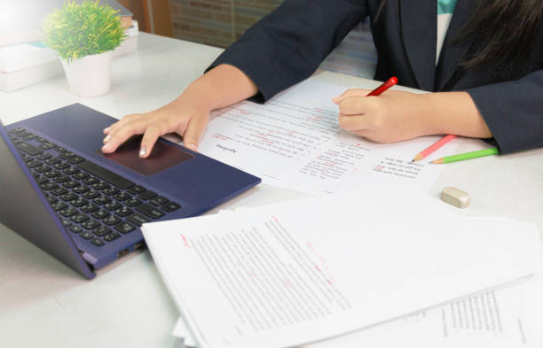 proofread on white table hand holding red pen over proofreading paper on white table editor stock pictures, royalty-free photos & images