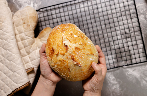 Beautifully baked bread with yellowish brown glazed crust, served on wooden board