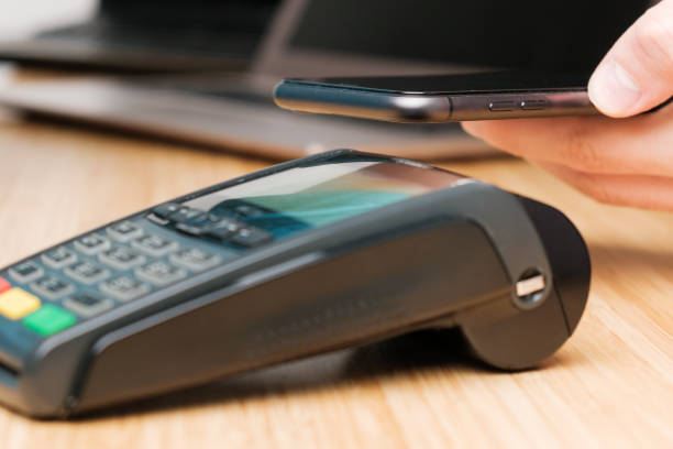 istock Man uses wireless terminal contactless payment with smartphone 1314704667