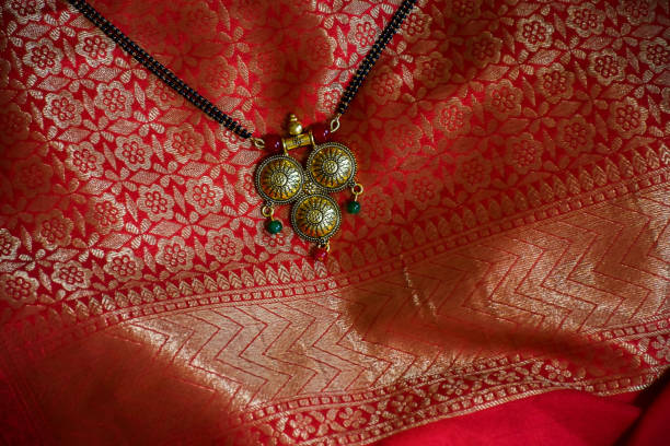 photo stock de belle mangalsutra d’or de fantaisie avec la chaîne noire de perle sur le beau fond rouge et doré de saree, capturé à l’intérieur. - black pearl pearl horizontal necklace photos et images de collection