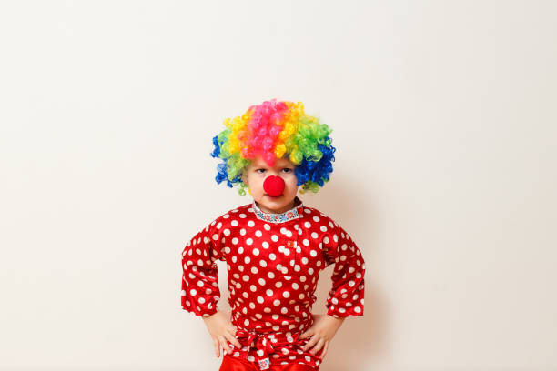 istock Hilarious five-year-old boy dances in clown costume and wig on white background 1314707315