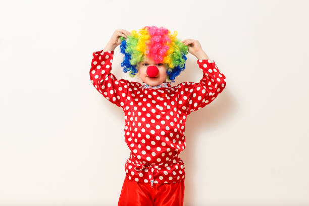 istock Hilarious five-year-old boy dances in clown costume and wig on white background 1314707329