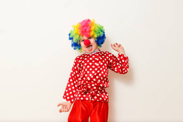 istock Hilarious five-year-old boy dances in clown costume and wig on white background 1314707334