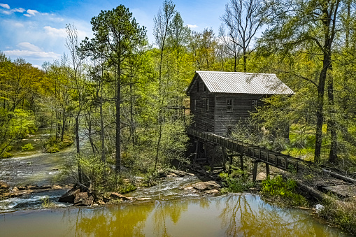 Opelika, Alabama, USA - April 7, 2021: Landscape of historic Bean's Mill located on Halawakee Creek in rural Lee County in the springtime.