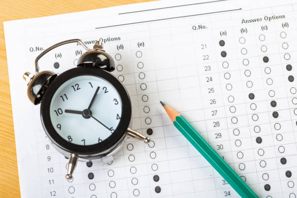 istock answer sheet, test in exercise and passing examination paper computer sheet with pencil alarm clock and pencil for education concept 1314710813