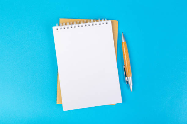 istock multiple school notepad on blue background, spiral notepad with blank page and ballpoint pen on table top view 1314710823